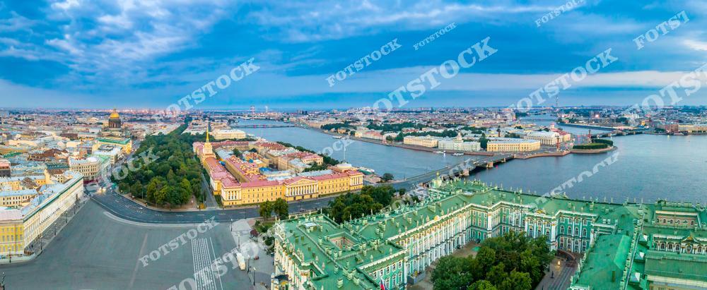 Панорамная фотография Санкт-Петербурга с высоты птичьего полета, на которой видны Эрмитаж, Адмиралтейство, Васильевский остров, Дворцовый мост, река Нева и мосты города. Съемка с дрона позволяет оценить масштаб исторического центра, архитектурные ансамбли, панораму набережных и величие Северной столицы России. Фотография передает атмосферу городского центра, гармонию рек и мостов с исторической архитектурой и идеально подходит для туристических публикаций, фотостоков, рекламы, оформления интерьеров и материалов о культурных и архитектурных достопримечательностях Петербурга.